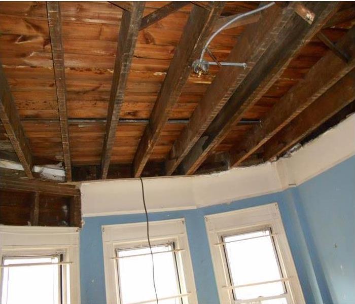 demolished ceiling, raw planking and roof joists, blue walls